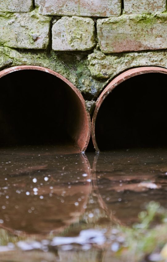 Sewers with toxic dirty water from metal pipes. Draining water from city sewer. Environmental pollution